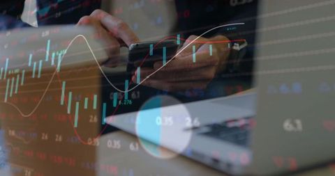Business professional analyzing stock market with smartphone and laptop