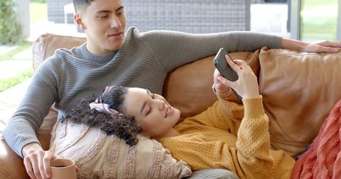 Couple Relaxing on Sofa, Sharing Cozy Moments Indoors