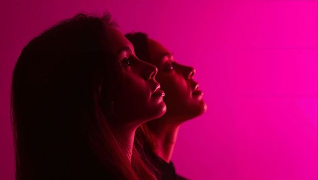 Artistic Double Portrait of Women with Vibrant Magenta Lighting