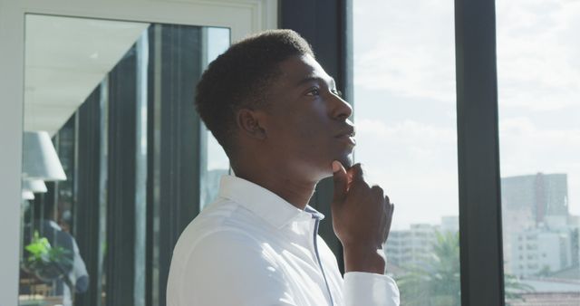 Pensive Young Professional Standing by Office Window - Download Free Stock Images Pikwizard.com