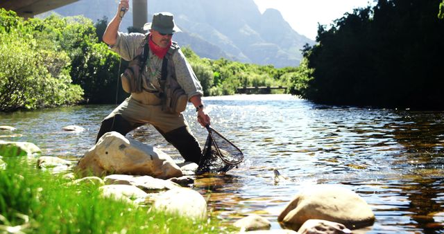 Fly fisherman catching trout in fishing net in river