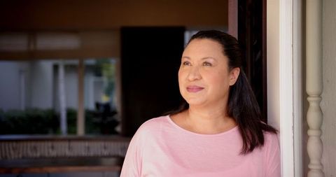 Smiling Mature Woman Enjoying Tranquil Moment in Doorway