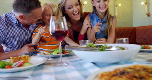 Smiling Family Enjoying Meal Together at Restaurant - Download Free Stock Images Pikwizard.com