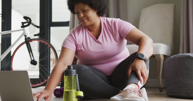 Woman Exercising at Home with Laptop and Water Bottle - Download Free Stock Images Pikwizard.com