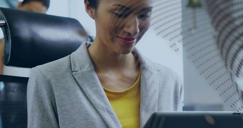 Smiling businesswoman working on laptop behind privacy panel in modern office