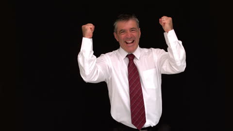 Happy Businessman Cheering with Raised Fists against Black Background