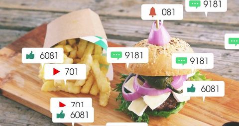 Skewering seeded burger with pickled onion, fries spilling on board, social engagement