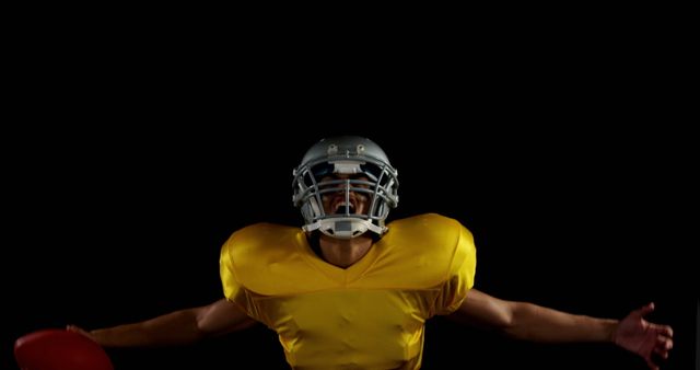 American football player celebrating with arms outstretched against black background - Download Free Stock Images Pikwizard.com