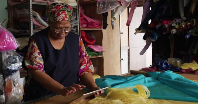 Seamstress using tablet in fabric store - Download Free Stock Images Pikwizard.com