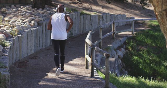 Man Jogging on Path Through Park Listening to Music - Download Free Stock Images Pikwizard.com