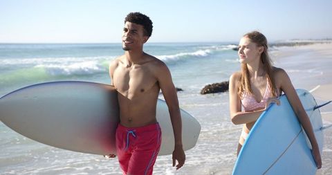 Young Man And Woman Surfing Enthusiasts with Surfboards on Sunny Beach