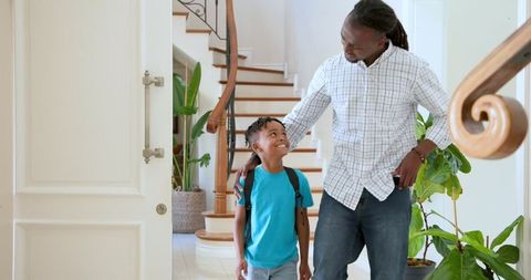 Father and Son Bonding in Home Hallway After School