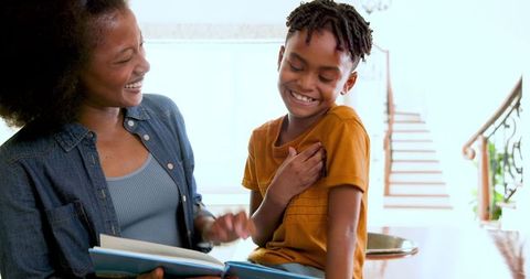 Mother and Son Reading Book Together at Home