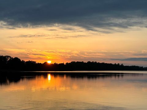 Tranquil beach sunset reflection with silhouette trees