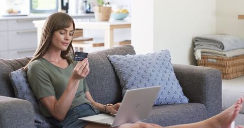 Woman Comfortably Shopping Online from Home Couch with Laptop