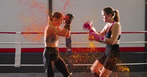 Female Boxers Sparring with Vibrant Powder Burst in Ring, Dynamic Fitness Training Action
