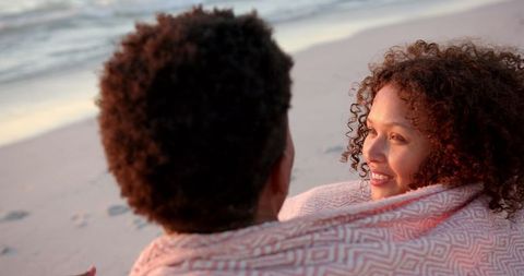 Couple sharing intimate moment by serene beach at sunset