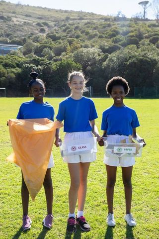 Diverse Teen Girls Engaged in Eco-Friendly Recycling Activity on Sports Field