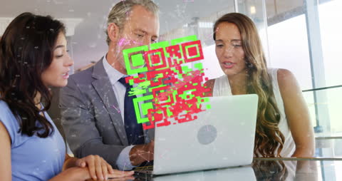 Coworkers Analyzing QR Code on Laptop in Futuristic Office