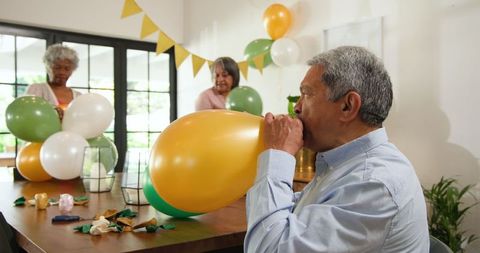 Seniors preparing for birthday celebration with balloons