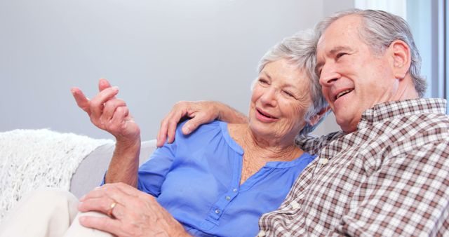 Cute elderly couple talking on sofa