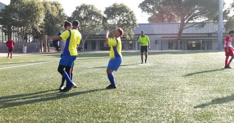 Soccer Players Celebrating Victory on Field in Daylight
