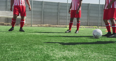 Team Training: Soccer Players Practicing Ball Control in Sunlit Field