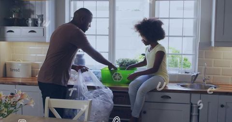 Father and daughter sorting recyclables on kitchen counter teaching home recycling