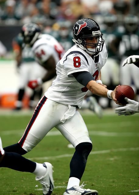 Image depicts an American football quarterback in the midst of passing the ball during a professional game. This can be used in sports-related articles, NFL news, player profile features, fitness and athletic training programs, and sports memorabilia promotions.