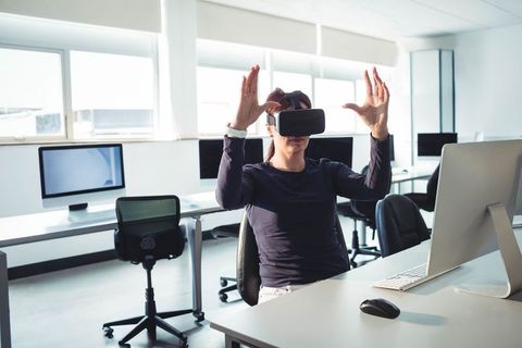 Woman Using VR Headset at Modern Workplace