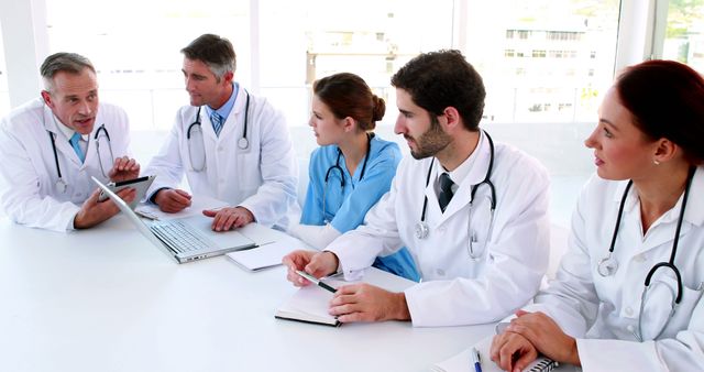 Medical team discussing plans and strategies in a meeting room. Can be used for advertisements, articles, or presentations related to healthcare, teamwork in medicine, collaboration among doctors, medical education, and hospital management.
