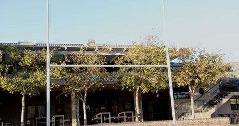 Rugby Goalposts with Clubhouse and Seating Background in Outdoor Sports Facility