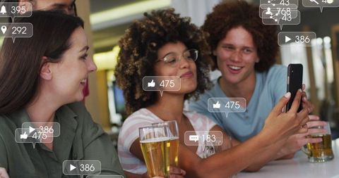 Diverse Friends Enjoying Social Media Interaction at Bar