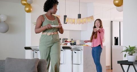 Interracial lesbian couple preparing birthday party at home