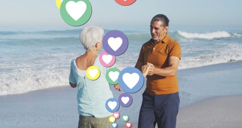 Senior Couple Dancing on Beach with Digital Heart Icons Overlay