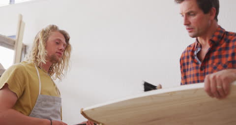 Surfboard Makers in Studio Discussing Design and Construction