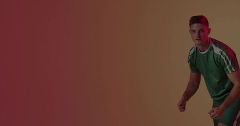 Athlete in Green Jersey Adopting Ready Stance on Colorful Gradient Backdrop for Fitness Branding