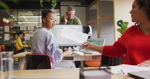 Collaborative Team Discussing Work in Modern Office Environment