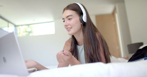 Smiling Teenage Girl Engaging in Video Call on Laptop from Home Bedroom