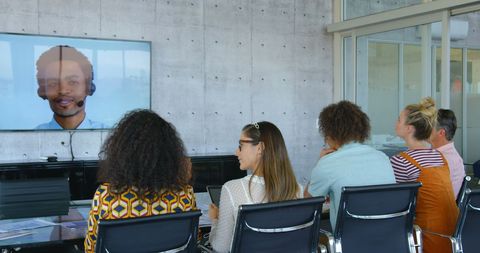 Diverse Team Attending Video Conference in Modern Office