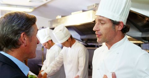 Chef Discussing Culinary Affairs in Professional Kitchen