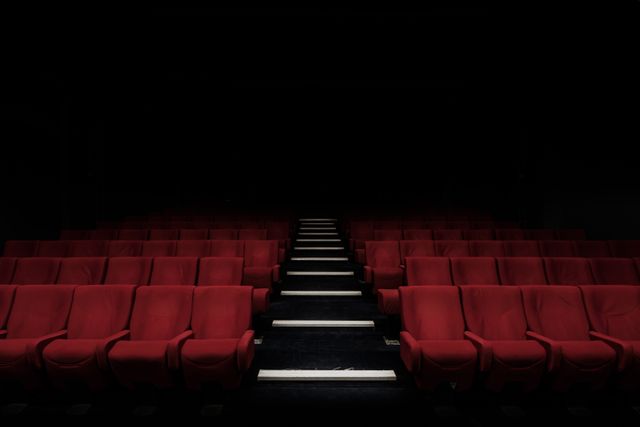 Modern interior of a empty movie theater auditorium with seats. Cinema and entertainment concept