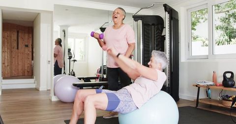 Senior couple exercising together in home gym