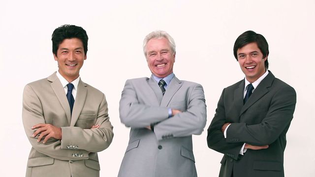 Group of three business professionals standing confidently with arms crossed against white background. Ideal for depicting themes of success, teamwork, and leadership in professional presentations and marketing materials.