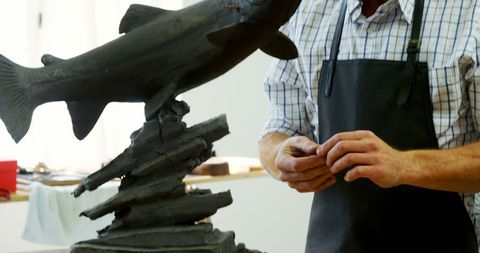 Skilled craftsman working on intricate fish sculpture