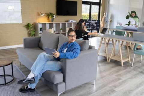 Sunlit modern coworking lounge with diverse female team collaborating on design plans