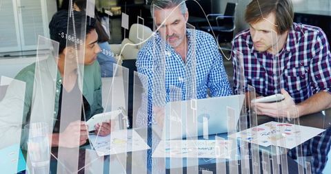 Business Team Analyzing Financial Graphs and Technology in Office Meeting