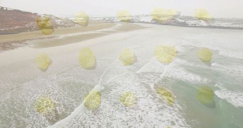 Aerial beach with geometric yellow circles overlaying winter landscape