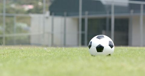 Soccer Ball on Green Field Near Schoolyard Building - Download Free Stock Images Pikwizard.com