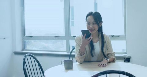 Businesswoman Smiling During Phone Call in Bright Office